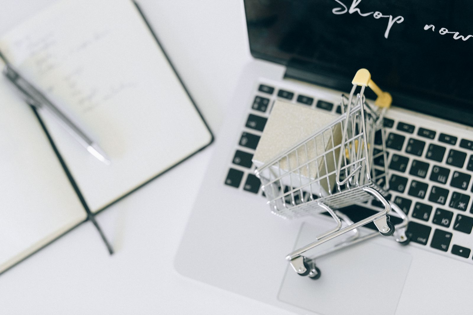Miniature shopping cart on a laptop keyboard, representing buying Axies on the Axie Marketplace