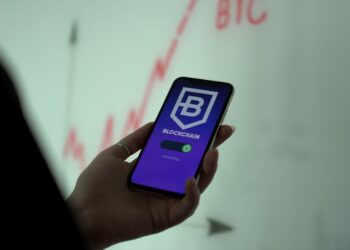 Hand holding a phone with a blockchain wallet app, the setup needed for the Axie Marketplace