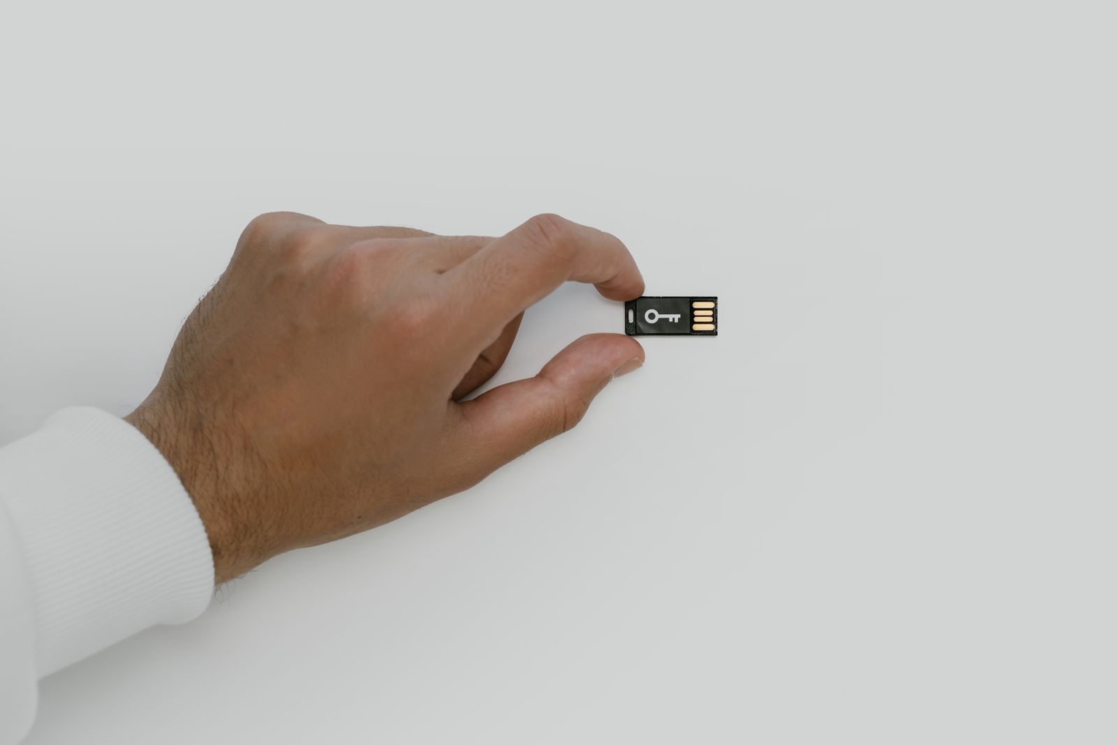 Hand holding a USB security key, a reminder to protect the Ronin Wallet used on the Axie Marketplace