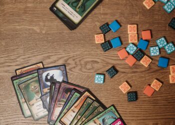 Fantasy trading cards and tokens on a wooden table, the style of play in Gods Unchained