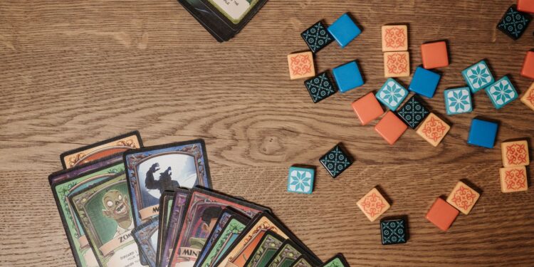 Fantasy trading cards and tokens on a wooden table, the style of play in Gods Unchained
