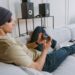 Young man playing a mobile game on a smartphone while sitting on a sofa