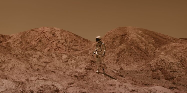 Person in a spacesuit walking across a barren, Mars-like landscape