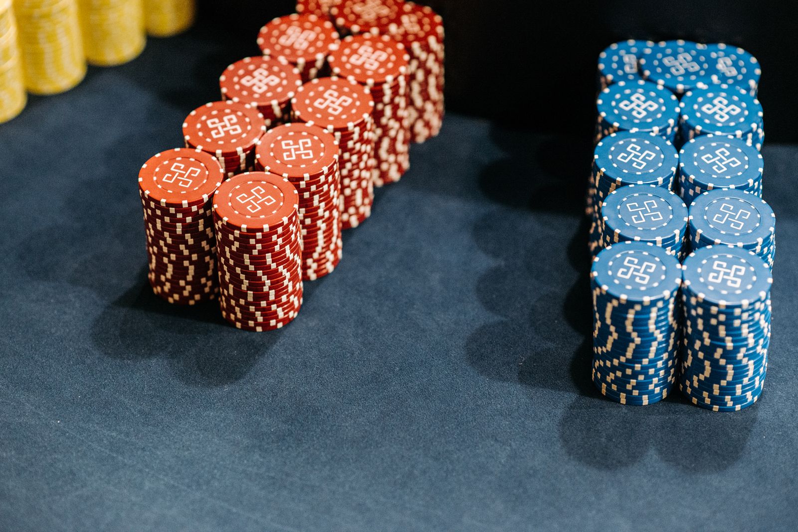 Stacks of red and blue chips on a dark table